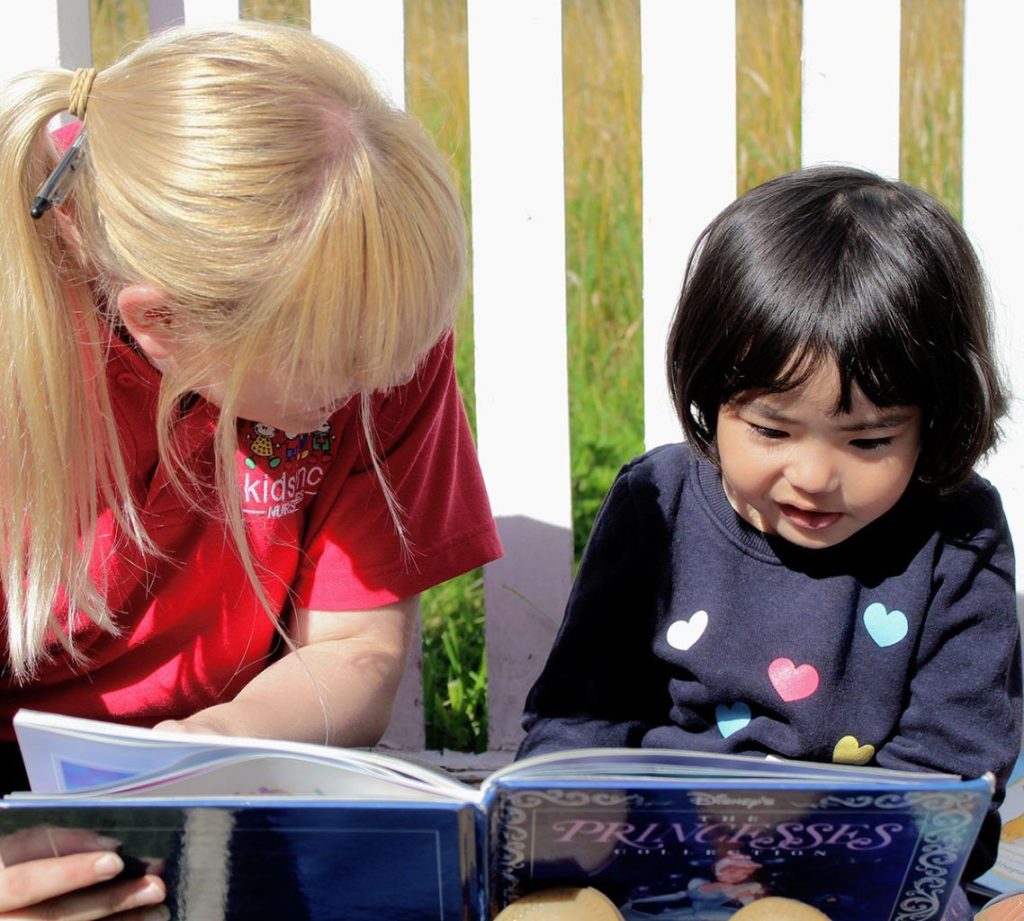 Nutrition | Kids Inc Nurseries Staff member reading a book with a young child