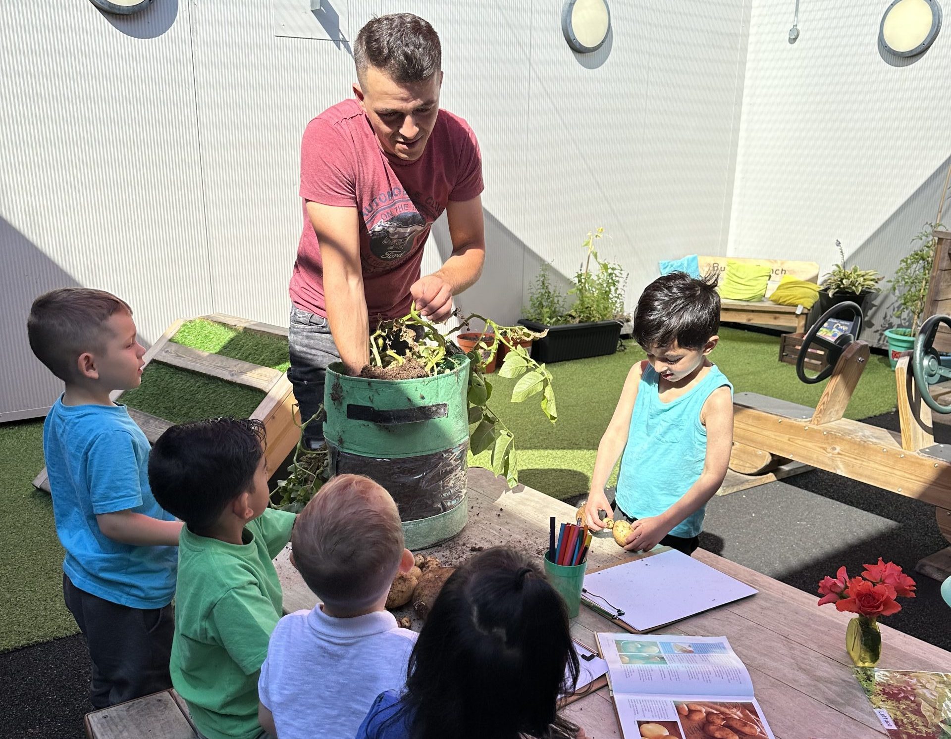 Team Member Spotlight: Chef Marian Ionita | Kids Inc Nurseries Adult showing some children a plant